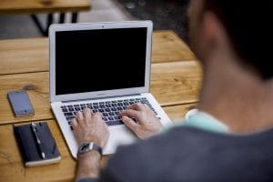 Man typing on his laptop